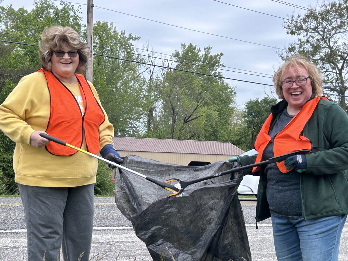 Two HHCU volunteers collect litter during a Bedford-area highway cleanup